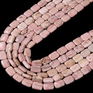 May include: A strand of pink and white rectangular gemstone beads. The beads are made of a natural stone with a marbled pattern.