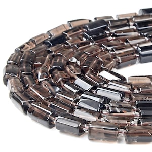 May include: A close-up of a strand of dark brown smoky quartz beads. The beads are faceted and have a rectangular shape. The beads are strung on a silver wire.