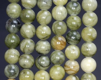 May include: Close-up of a strand of round, polished beads in shades of green, cream, and brown. The beads have a marbled appearance, with variations in color and pattern. The beads are strung together, creating a textured surface.