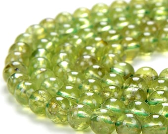 May include: A strand of round, green gemstone beads. The beads are translucent and have a slight shimmer.