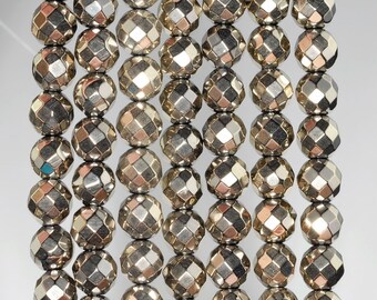 May include: A strand of silver-toned faceted beads. The beads are round and have a geometric pattern. The beads are strung on a clear thread.