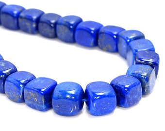 Puede incluir: Una hebra de cuentas de piedra preciosa de lapislázuli azul oscuro, cada cuenta tiene forma de cubo con bordes ligeramente redondeados.
