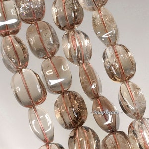 May include: A strand of translucent brown gemstone beads with a reddish-brown wire running through the center of each bead. The beads are oval shaped and have a smooth, polished finish.