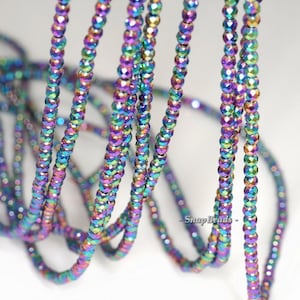 May include: A strand of iridescent faceted beads in shades of purple, blue, green, and gold. The beads are small and round, and they are strung on a clear thread. The beads are arranged in a loose, flowing pattern.