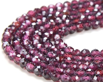 May include: A strand of faceted garnet beads in a deep purple hue. The beads are round and have a smooth, polished finish.
