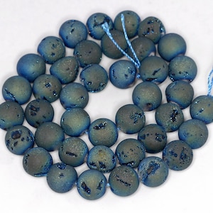 May include: A strand of blue agate beads with a sparkly, iridescent finish. The beads are round and have a textured surface.