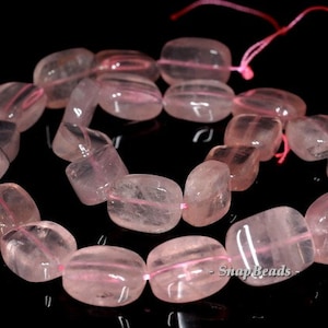 Puede incluir: Una hebra de cuentas de cuarzo rosa, cada cuenta es facetada y tiene forma rectangular. Las cuentas están enhebradas en un hilo rosa delgado.