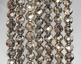 May include: A strand of silver faceted beads, each bead has a unique geometric shape. The beads are strung on a clear thread and are ready to be used for jewelry making.