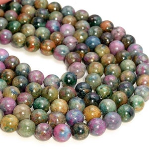 Peut inclure: Un brin de perles rondes en pierres précieuses multicolores. Les perles sont un mélange de vert, bleu, rose et marron.