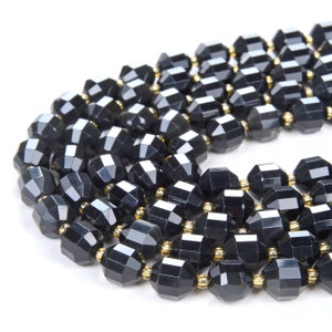 May include: A strand of black faceted glass beads with gold accents. The beads are arranged in a circular pattern, creating a decorative and elegant look.