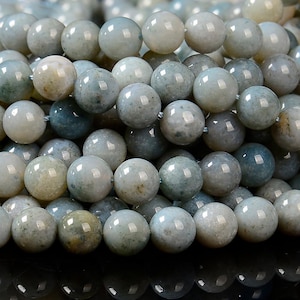 May include: A strand of round, light blue and green agate beads. The beads have a mottled, cloudy appearance.