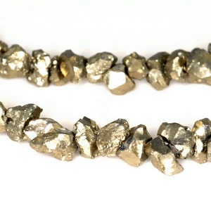 May include: A strand of gold-toned pyrite beads, each bead is a rough, irregular shape.