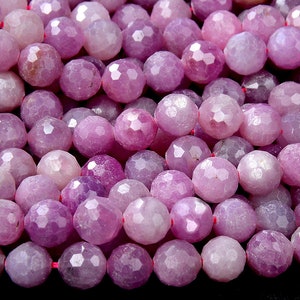 May include: A strand of faceted purple gemstone beads. The beads are round and have a smooth, polished finish.