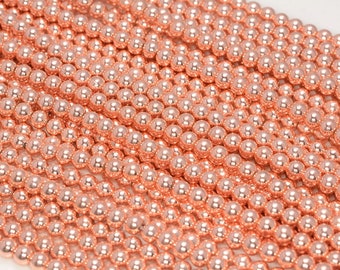 Op de afbeelding: Een streng ronde kralen in rosé goud. De kralen zijn glad en glanzend.