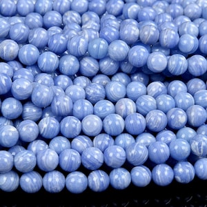 May include: A strand of light blue agate beads. The beads are round and have a smooth, polished finish. The agate has a natural, swirling pattern.