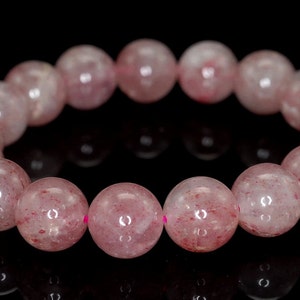 K&ouml;nnte beinhalten: Ein Armband aus rosa Quarz mit runden Perlen. Die Perlen sind durchscheinend und haben einen leichten roten Farbton.