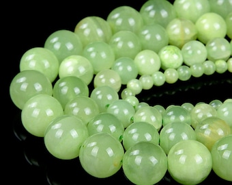 May include: A strand of light green jade beads. The beads are round and smooth, and they are strung together on a clear thread.
