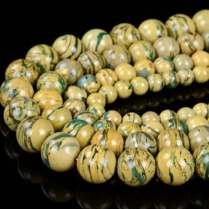 May include: A strand of round, green and yellow patterned beads. The beads are made of natural stone and have a smooth, polished finish.
