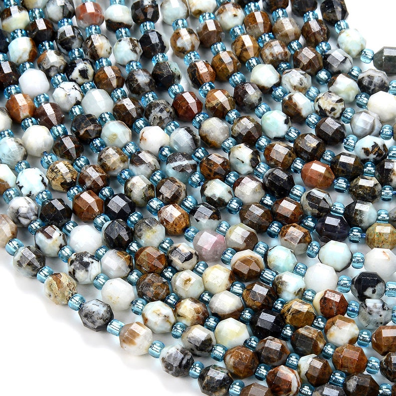 May include: A strand of faceted gemstone beads in shades of brown, white, and blue. The beads are irregularly shaped and have a natural, organic look.