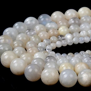 May include: A strand of white moonstone beads, each bead is round and smooth with a subtle iridescent sheen.