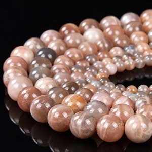 May include: A strand of sunstone beads in various shades of brown, beige, and grey. The beads are round and have a smooth, polished finish.