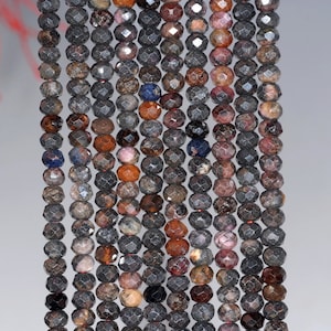 Peut inclure: Un brin de perles de pierres précieuses facettées dans des tons de noir, brun, rose et bleu. Les perles sont enfilées sur un fil transparent et sont prêtes à être utilisées pour la fabrication de bijoux.