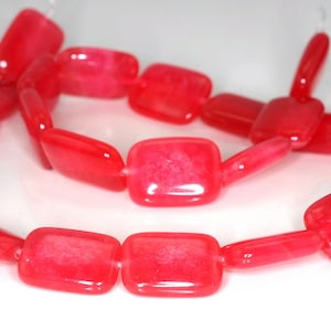 May include: A strand of bright pink, rectangular, gemstone beads. The beads are smooth and glossy.