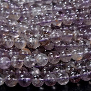 Peut inclure: Un brin de perles rondes d'améthyste violette translucide. Les perles ont un aspect légèrement nuageux et mesurent environ 8 mm de diamètre.