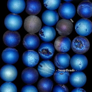 May include: A strand of blue agate beads with a frosted finish. The beads have a natural crystal texture and some have a slight iridescent shimmer.