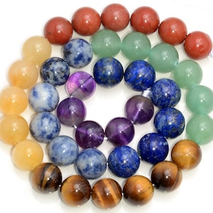 May include: A set of round, smooth gemstone beads in various colors, including red, orange, yellow, green, blue, purple, and brown. The beads are arranged in a circle, with the colors corresponding to the seven chakras.