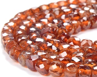 May include: A strand of faceted brown garnet beads. The beads are all approximately the same size and shape, and they have a smooth, polished finish.