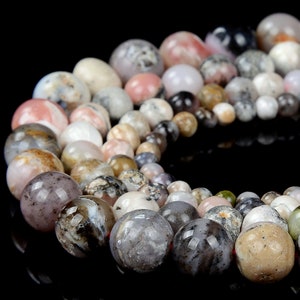 May include: A strand of round, multi-colored agate beads with brown, white, pink, and gray tones. The beads are strung on a clear elastic cord.