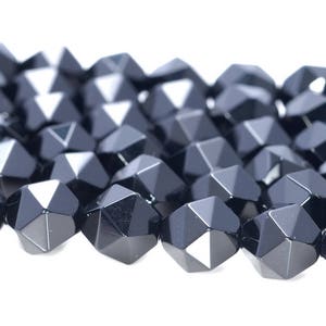 May include: Black faceted gemstone beads, each bead is a multi-sided geometric shape with a shiny finish.
