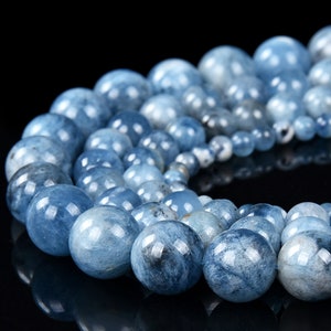 May include: A strand of light blue aquamarine beads. The beads are round and have a smooth, polished finish.