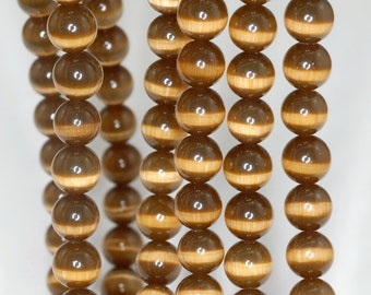 May include: A strand of brown and gold tiger eye beads. The beads are round and have a smooth, polished finish.