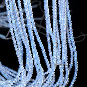 May include: A strand of light blue opal beads, approximately 4mm in diameter. The beads are round and have a smooth, polished finish. The beads are strung on a clear thread and are ready to be used for jewelry making.