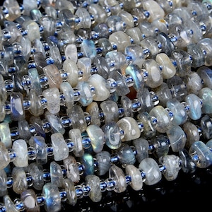 May include: A strand of gray and blue labradorite gemstone beads. The beads are irregular in shape and have a smooth, polished finish. The beads are strung on a clear elastic cord.