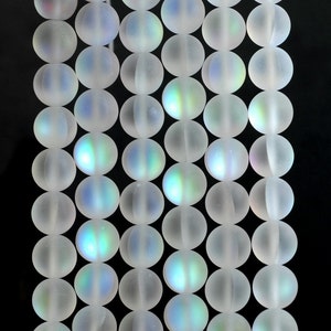 May include: A strand of iridescent white glass beads. The beads are round and have a frosted finish.