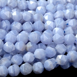 Op de afbeelding: Een close-up van een streng blauwe agaat kralen. De kralen zijn gefacetteerd en hebben een lichtblauwe kleur met witte en grijze banden.