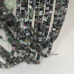 Peut inclure: Un brin de perles de pierres précieuses noires, vertes et roses. Les perles sont facettées et ont une finition brillante. Les perles sont enfilées sur un cordon élastique transparent.