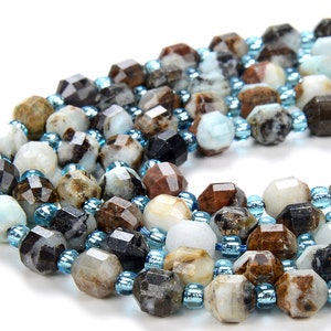May include: A strand of faceted gemstone beads in shades of brown, white, and black, interspersed with smaller blue beads.