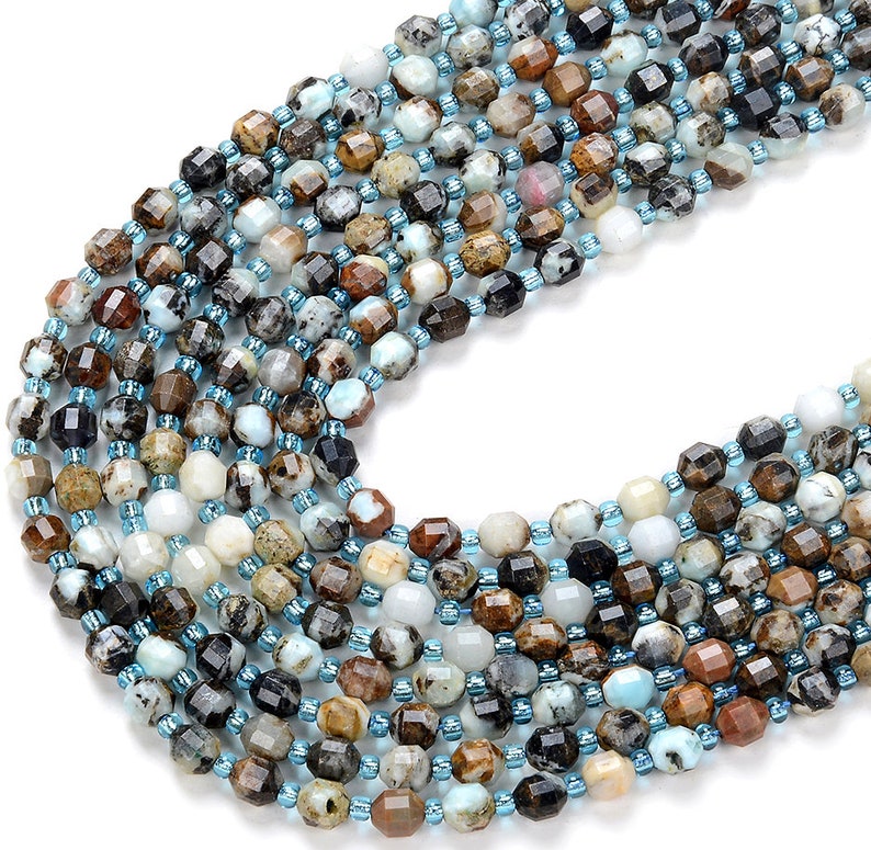 May include: A strand of faceted gemstone beads in shades of brown, blue, and white. The beads are approximately 6mm in size and have a natural, irregular shape.
