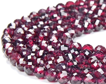 May include: A strand of deep red faceted garnet beads. The beads are round and have a smooth, polished finish.