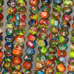 May include: A strand of colorful, multi-faceted, round beads. The beads are a mix of green, blue, orange, and red with a speckled, marbled pattern. The beads are approximately 10mm in diameter.