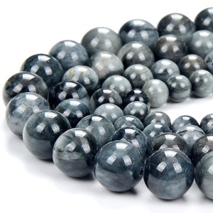 May include: A strand of round, grey and blue tiger's eye beads. The beads are smooth and polished, with a subtle shimmer.