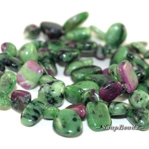May include: A strand of green, pink, and black gemstone beads. The beads are tumbled and have a smooth, polished finish. The beads are approximately 10mm in size.