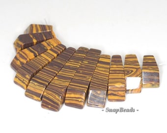 May include: A collection of rectangular beads with a striped pattern in shades of brown and yellow. The beads are arranged in a curved shape, showcasing their unique design. The text "SnapBeads" is visible.