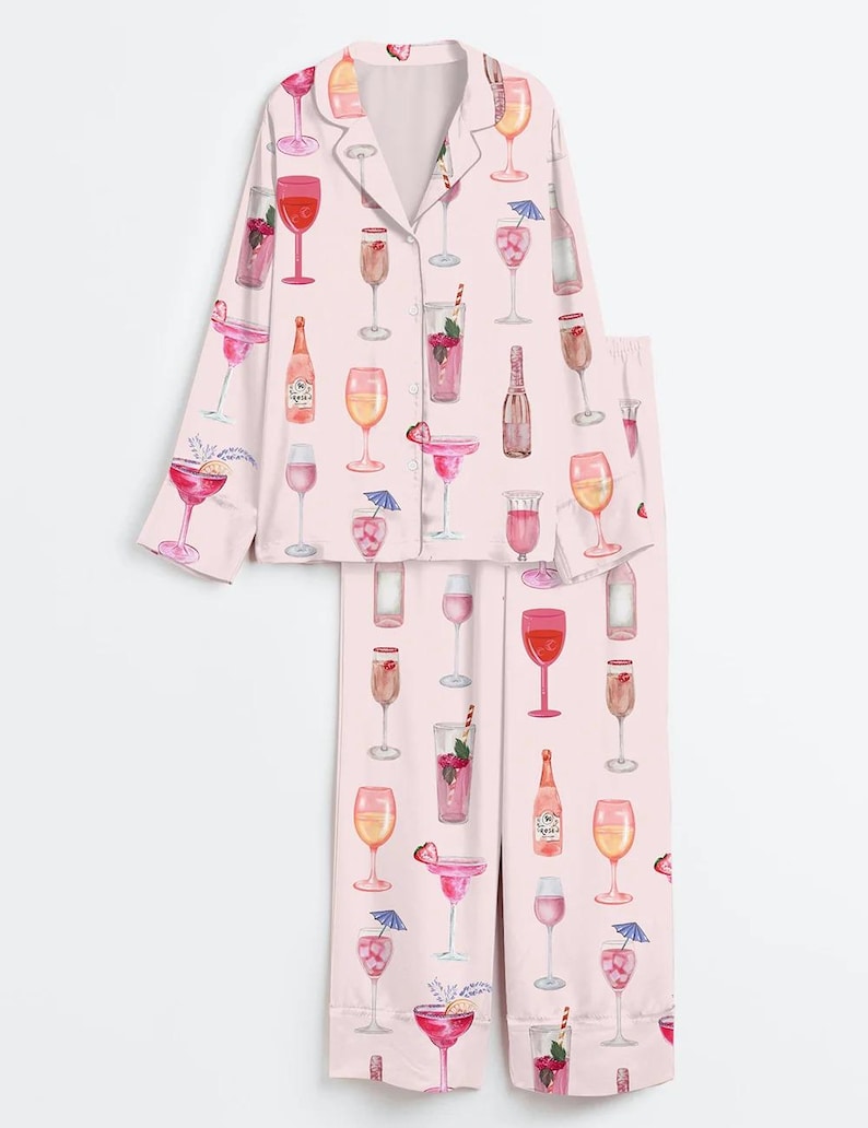 Peut inclure: Ensemble de pyjama rose clair avec un motif aquarelle de divers cocktails et verres &agrave; vin. Le haut &agrave; manches longues a une fermeture boutonn&eacute;e et le pantalon est long. L'ensemble est en mati&egrave;re douce et soyeuse.