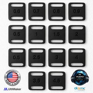 Peut inclure: Une collection de seize objets noirs rectangulaires aux coins arrondis, chacun portant un numéro. Les numéros varient de 0,5 à 4,5. Les objets sont disposés en grille. L'image comprend également un autocollant "Proudly Made in USA" et des logos.