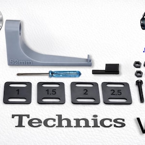 May include: A gray 52mm bracket, a blue-handled screwdriver, a small black rectangular piece, five black square plates labeled 0.5 through 2.5, four black nuts, four black washers, and four black bolts, all labeled Technics V2.